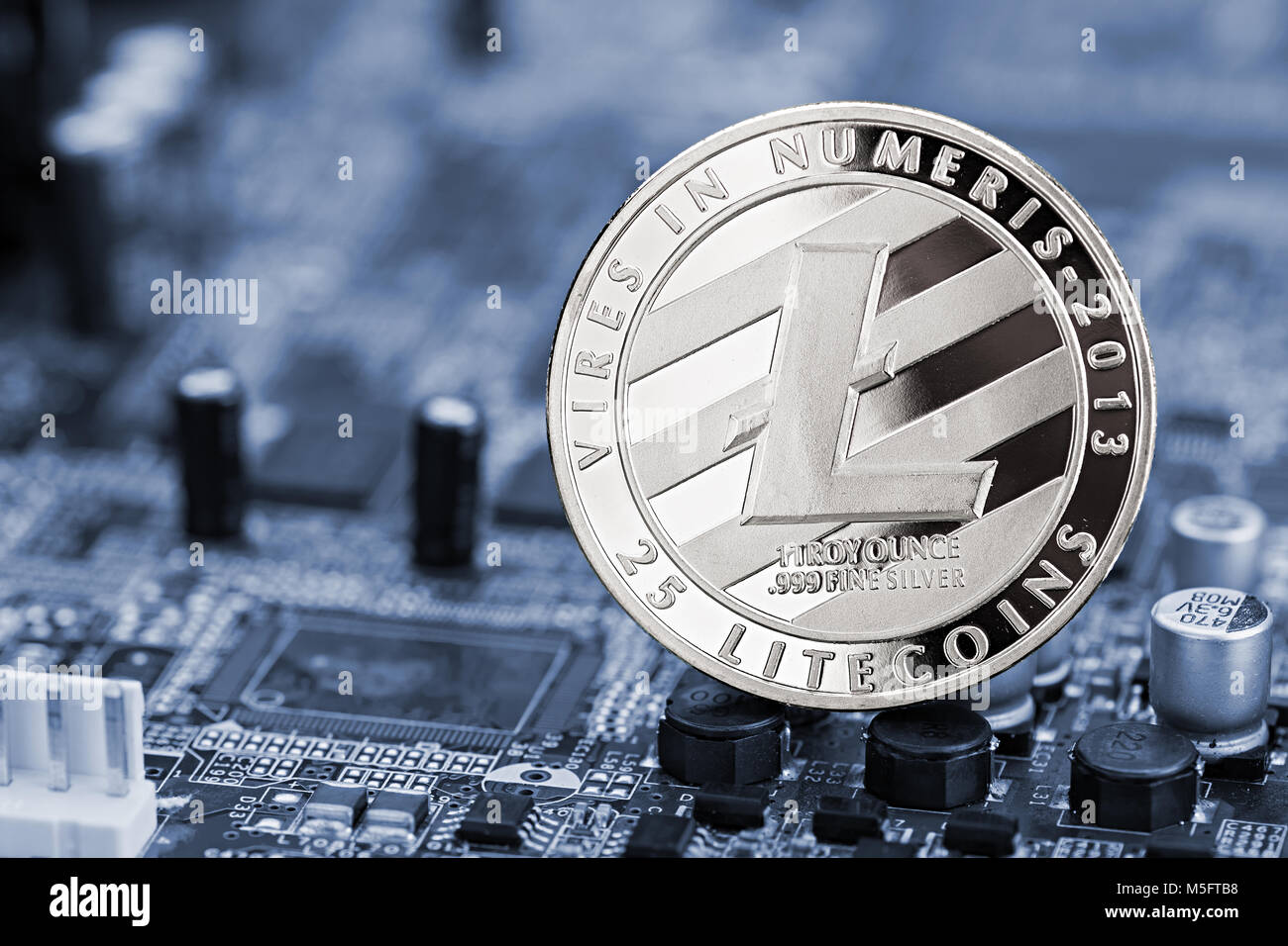 Litecoin moneta d'argento su blue chip della scheda madre di data mining digitale computer valuta hardwarecrypto finanziaria il concetto di sfondo Foto Stock