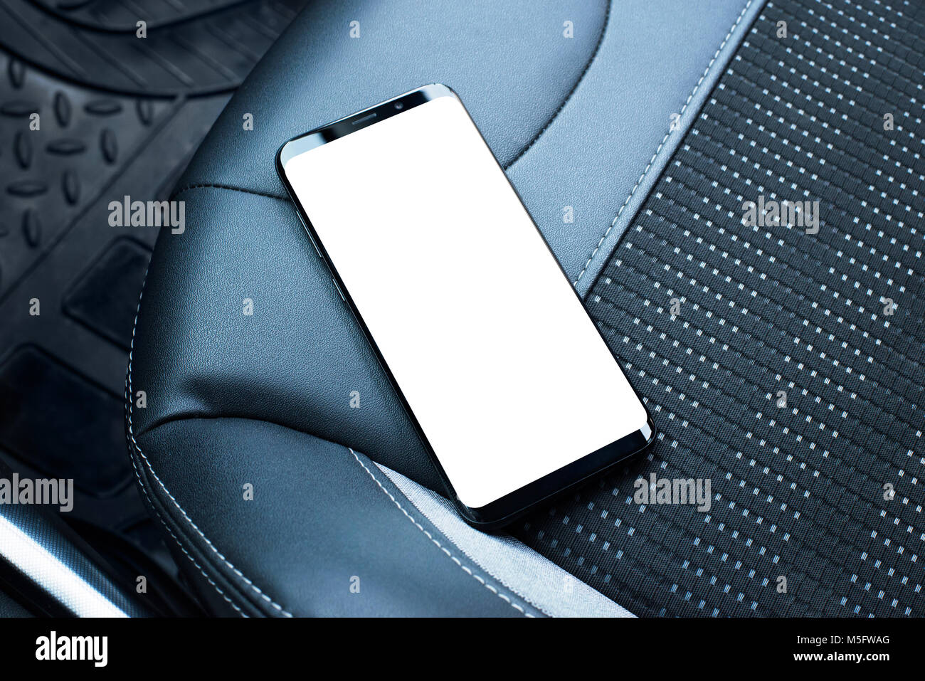 Telefono cellulare sul sedile in pelle di un'auto. Schermo isolato per app o un sito web mockup promozione. Foto Stock