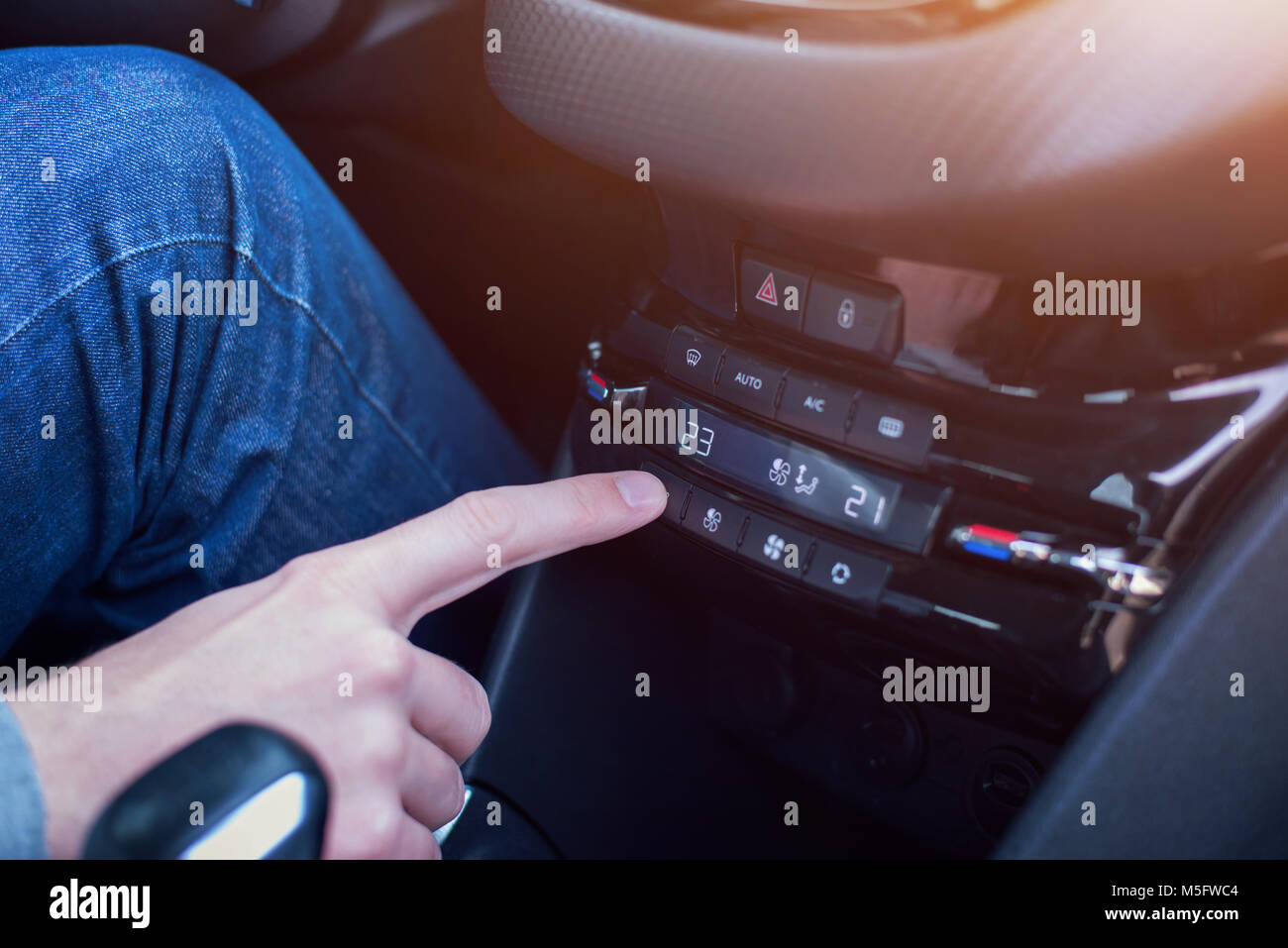 La variazione della temperatura del condizionatore d'aria in auto. Mano dispositivo di climatizzazione. Foto Stock