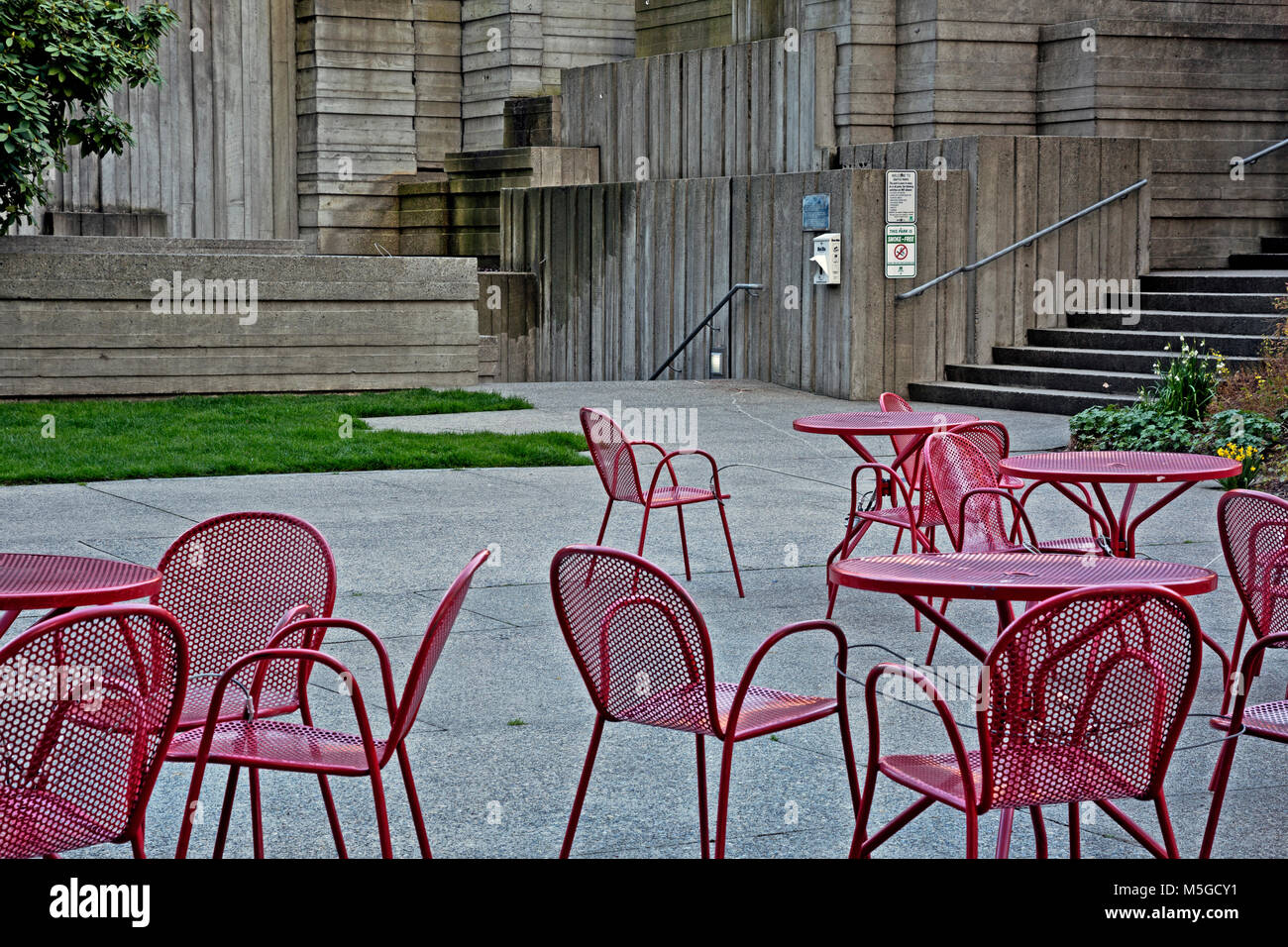 WASHINGTON - Rosso tavoli e sedie per rilassarsi e mangiare il pranzo nella centrale Plaza area di Freeway Park, con il Canyon area oltre Foto Stock