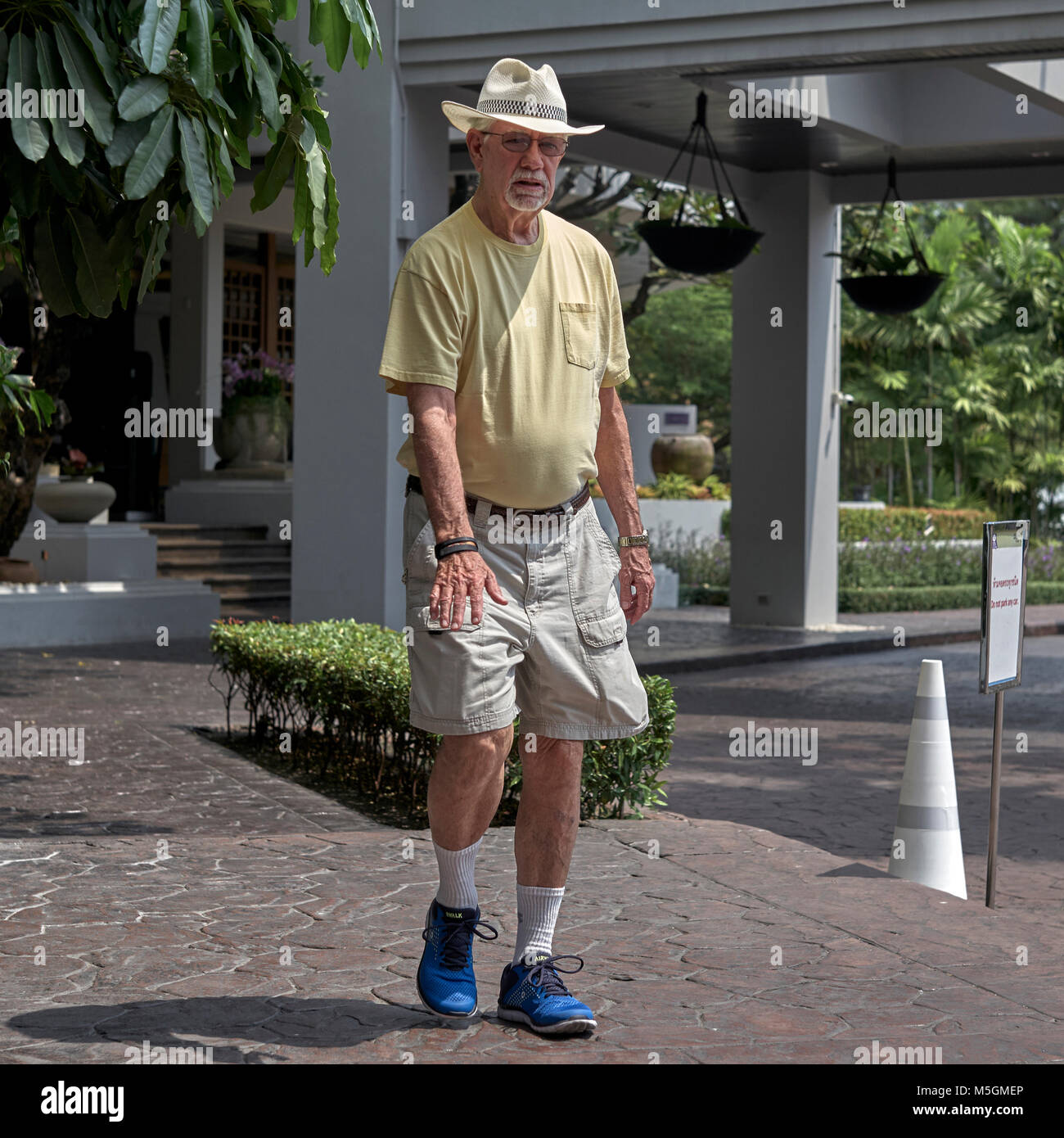 Uomo maturo indossare pantaloncini corti e cappello per il sole Foto Stock