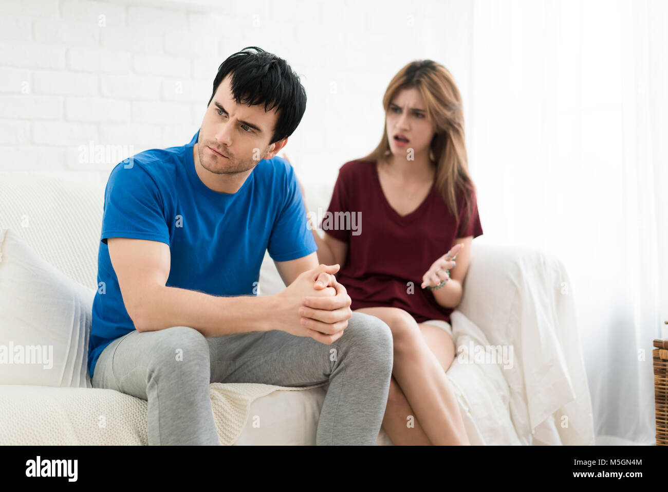 Giovane aventi argomento conflitto, cattive relazioni. Arrabbiato furia urlando donna uomo stress in casa. Foto Stock