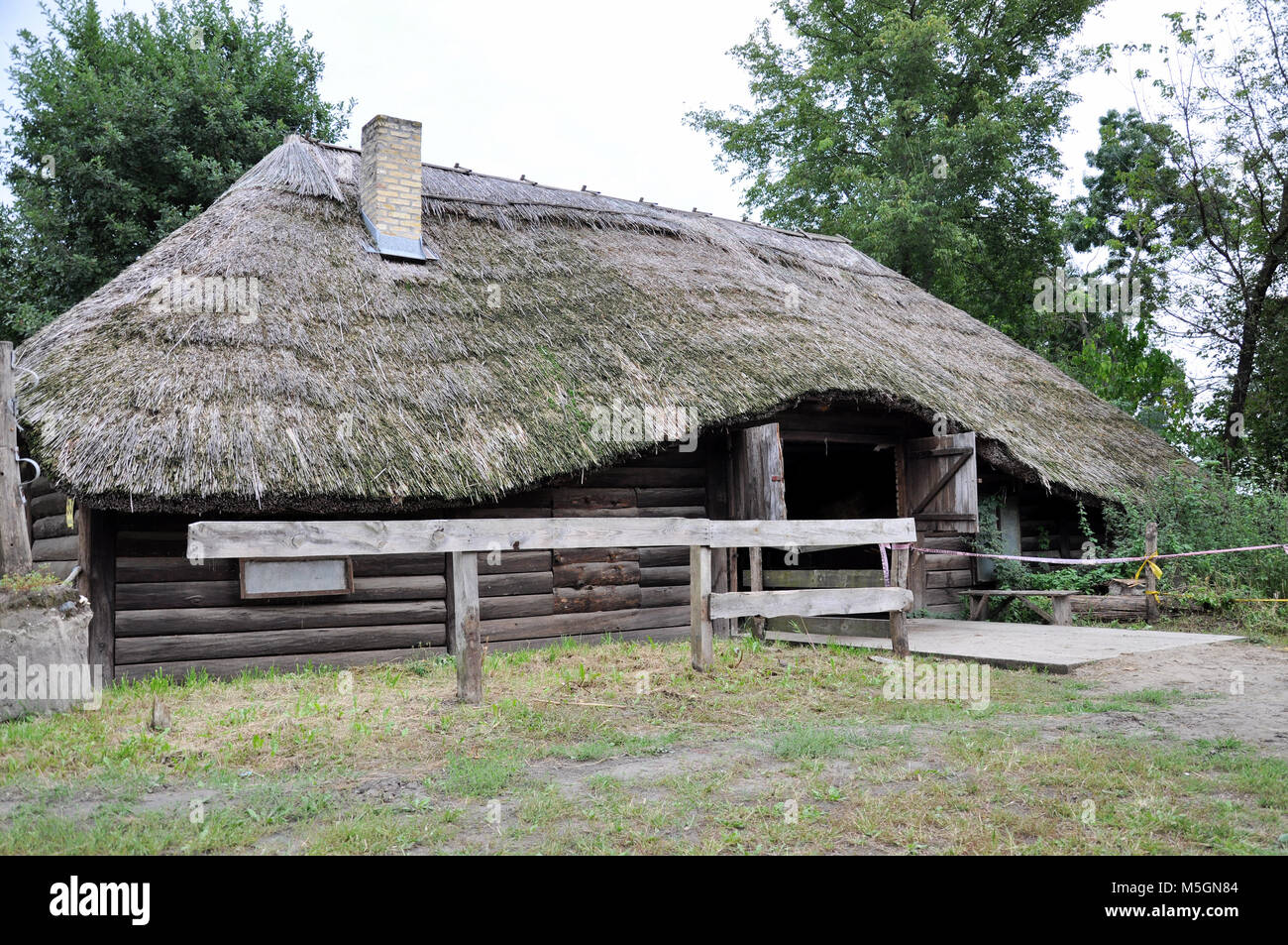 Grande Vecchia casa in legno per cavalli con un tetto di paglia Foto Stock