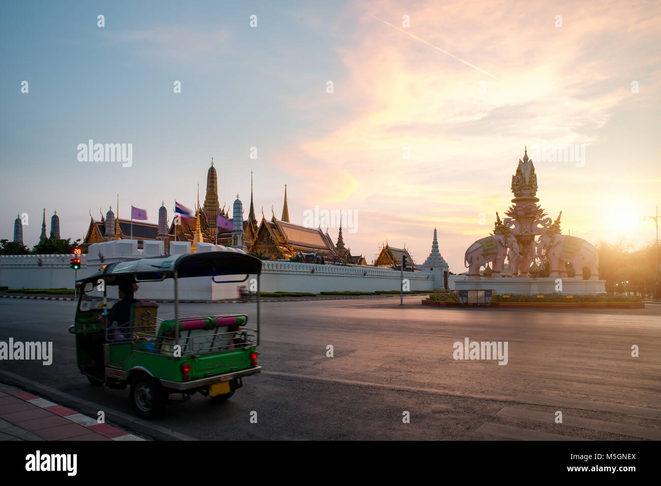 Tuk-tuk per le autovetture da visitare intorno al Grand Palace di Bangkok con Cielo di tramonto sullo sfondo Foto Stock