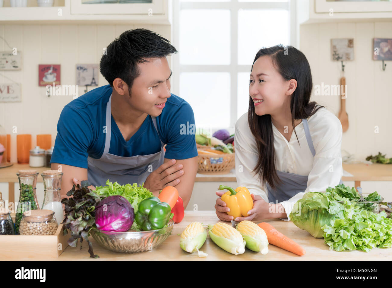 Giovani asiatici giovane preparare il cibo insieme al contatore in cucina. Felice amore giovane concetto. Foto Stock