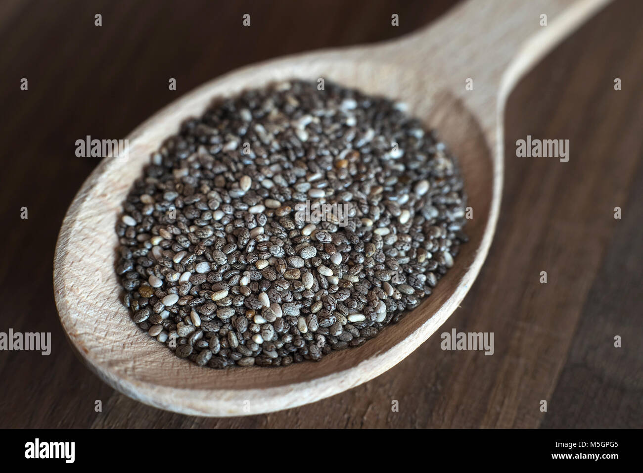 Nutrienti semi di chia su un cucchiaio di legno, close up Foto Stock