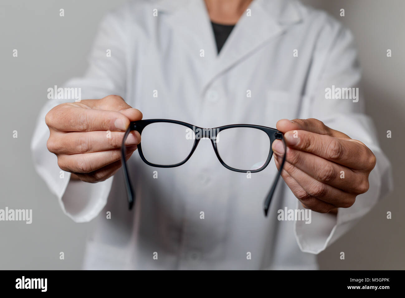 Primo piano di un giovane uomo ottico di portare un paio di occhiali per l'osservatore Foto Stock