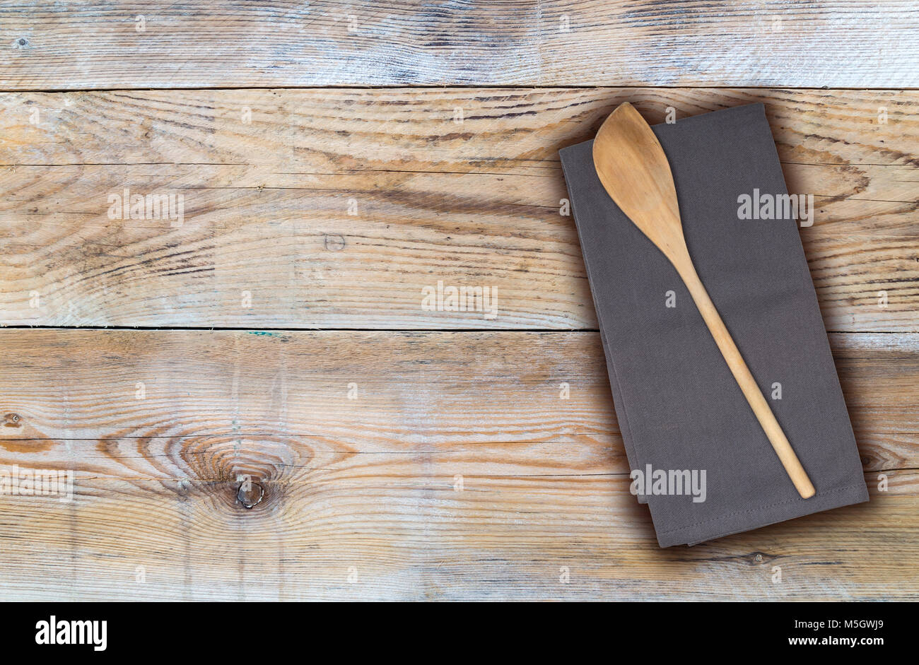 Il cucchiaio di legno e asciugamani da cucina in legno non trattato. Foto Stock