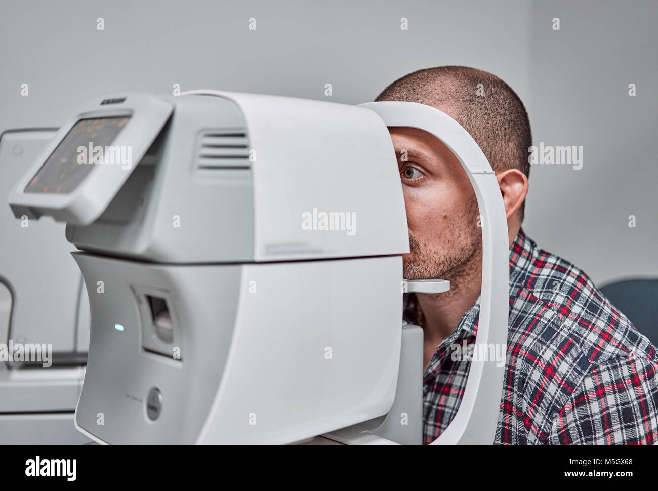 L'uomo controlla la sua visione sulla macchina Foto Stock