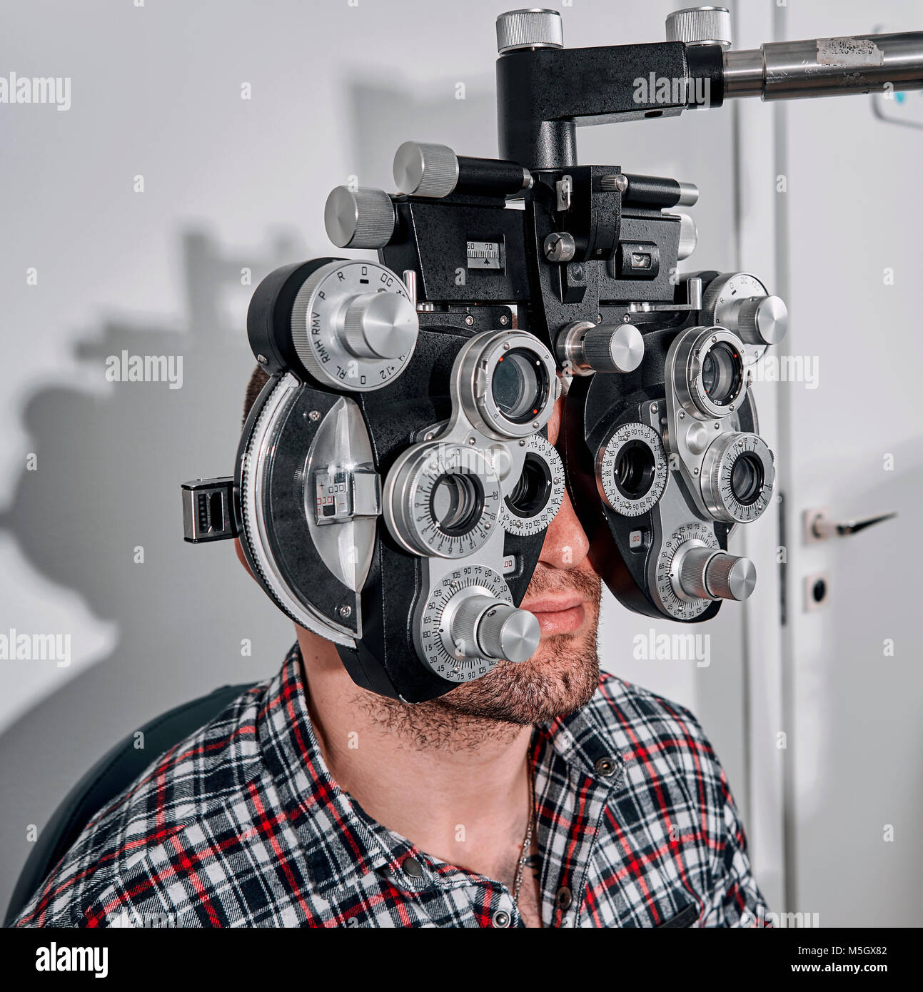 L'uomo controlla la sua visione sulla macchina Foto Stock