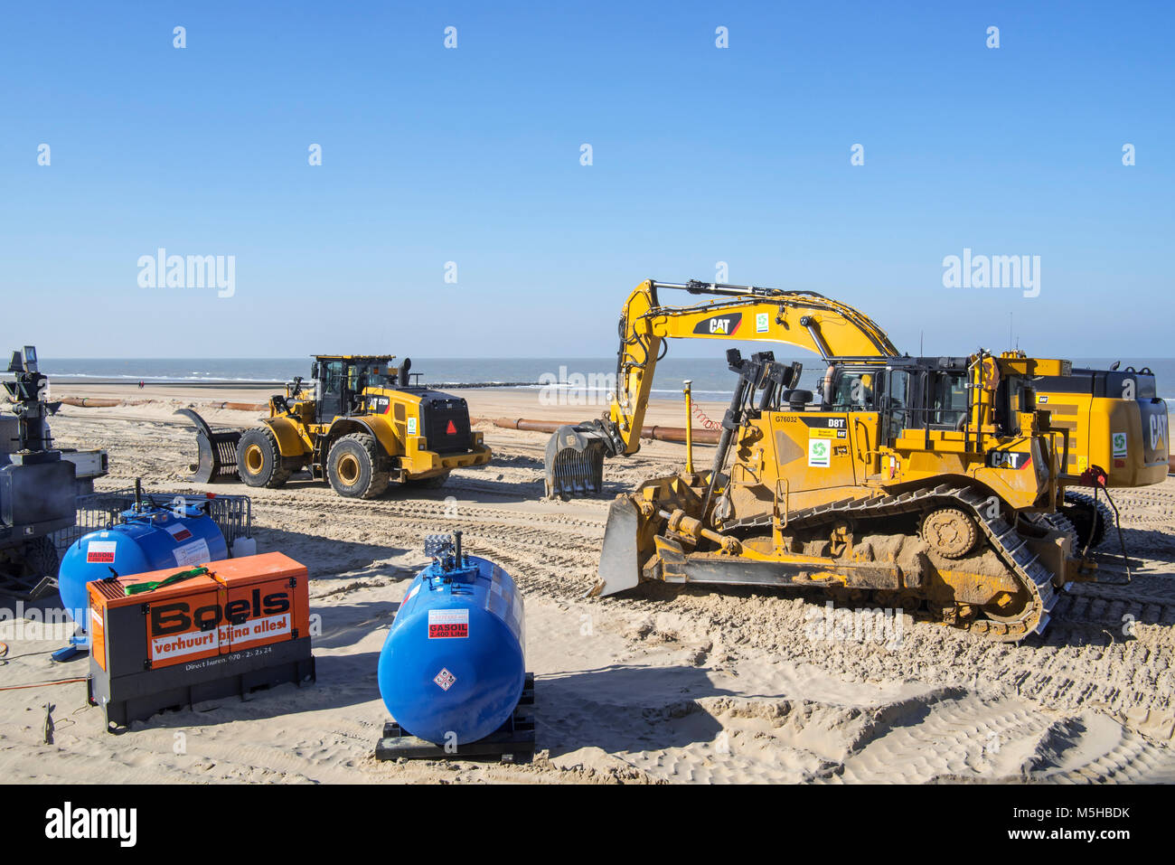 Rifornimento di sabbia / spiaggia nutrimento mediante dragaggio Internazionale / DEME con i bulldozer per ridurre i danni provocati dalla tempesta di strutture costiere in Belgio Foto Stock