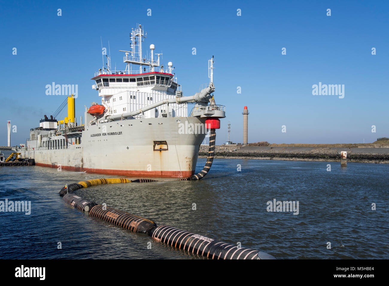 Trailing tramoggia di aspirazione draga Alexander von Humboldt nel porto di Ostenda sabbia di scarico tramite flessibili lunghi / pipeline flottante a spiagge, Belgio Foto Stock