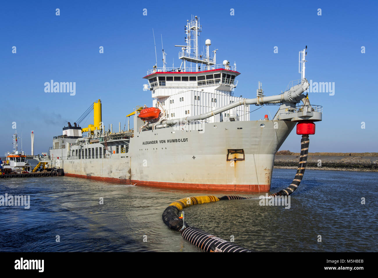 Trailing tramoggia di aspirazione draga Alexander von Humboldt nel porto di Ostenda sabbia di scarico tramite flessibili lunghi / pipeline flottante a spiagge, Belgio Foto Stock