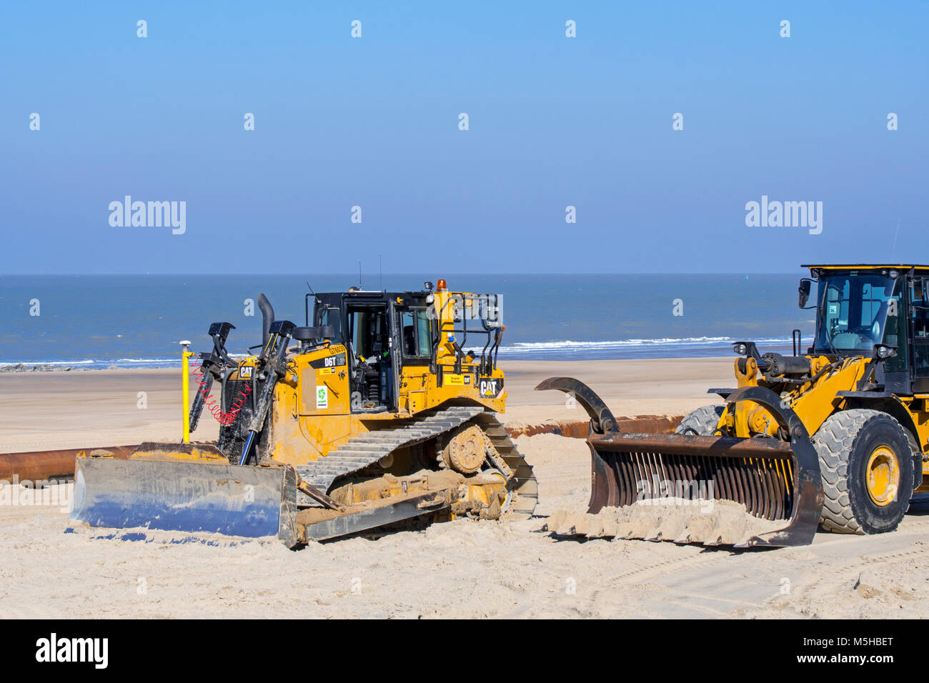 Bulldozer utilizzato per il rifornimento di sabbia / spiaggia nutrimento per rendere la spiaggia più ampia per ridurre i danni provocati dalla tempesta di strutture costiere lungo la costa belga Foto Stock