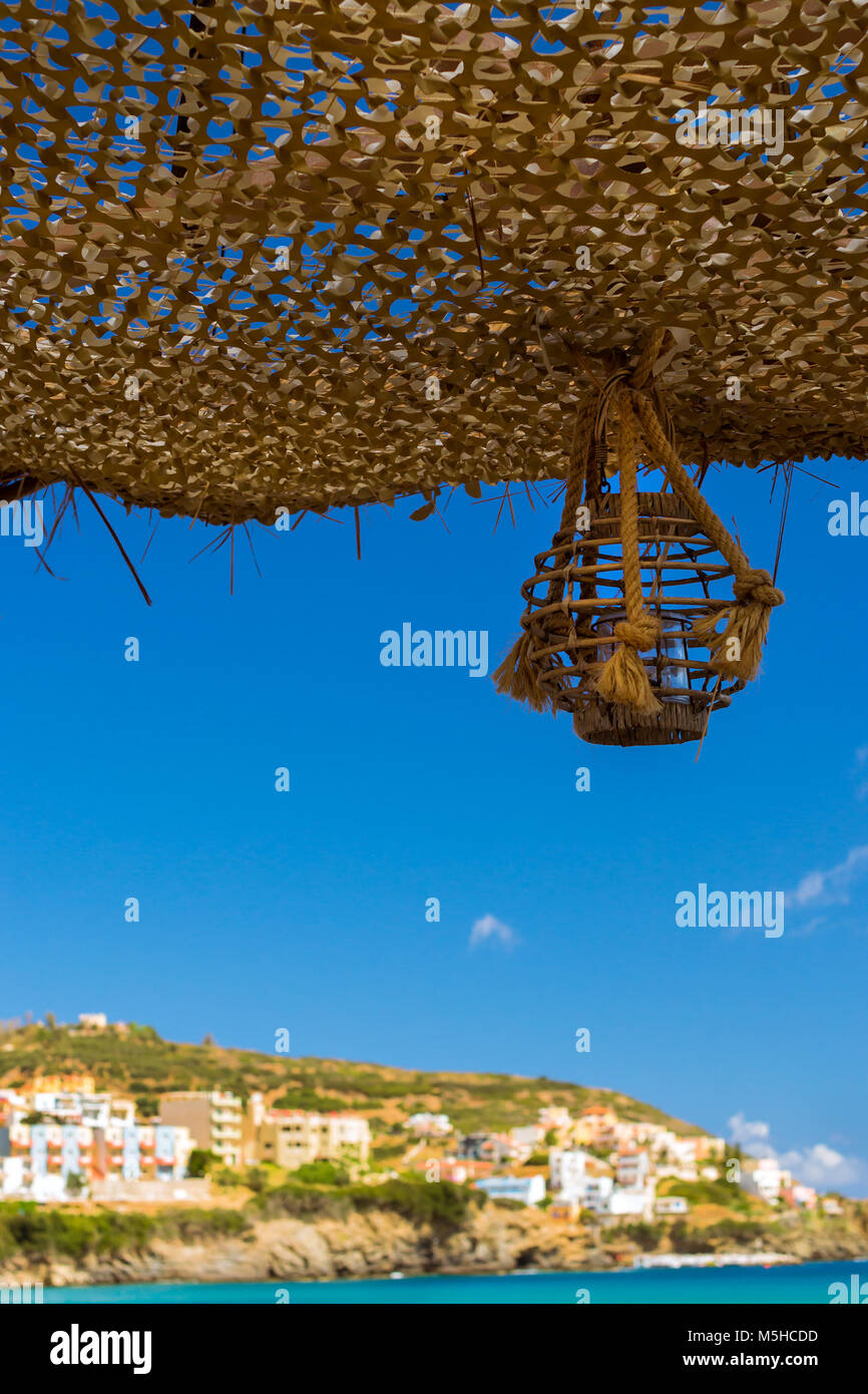 Candelieri con candele appeso sulle funi in spiaggia cafè sul lungomare. Livadi spiaggia nella baia del villaggio resort Bali. Creta, Grecia Foto Stock