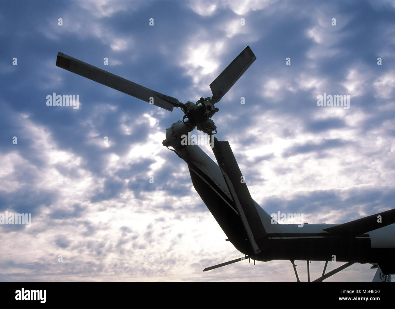 Silhouette di elicottero rotore di coda contro il cielo nuvoloso Foto Stock