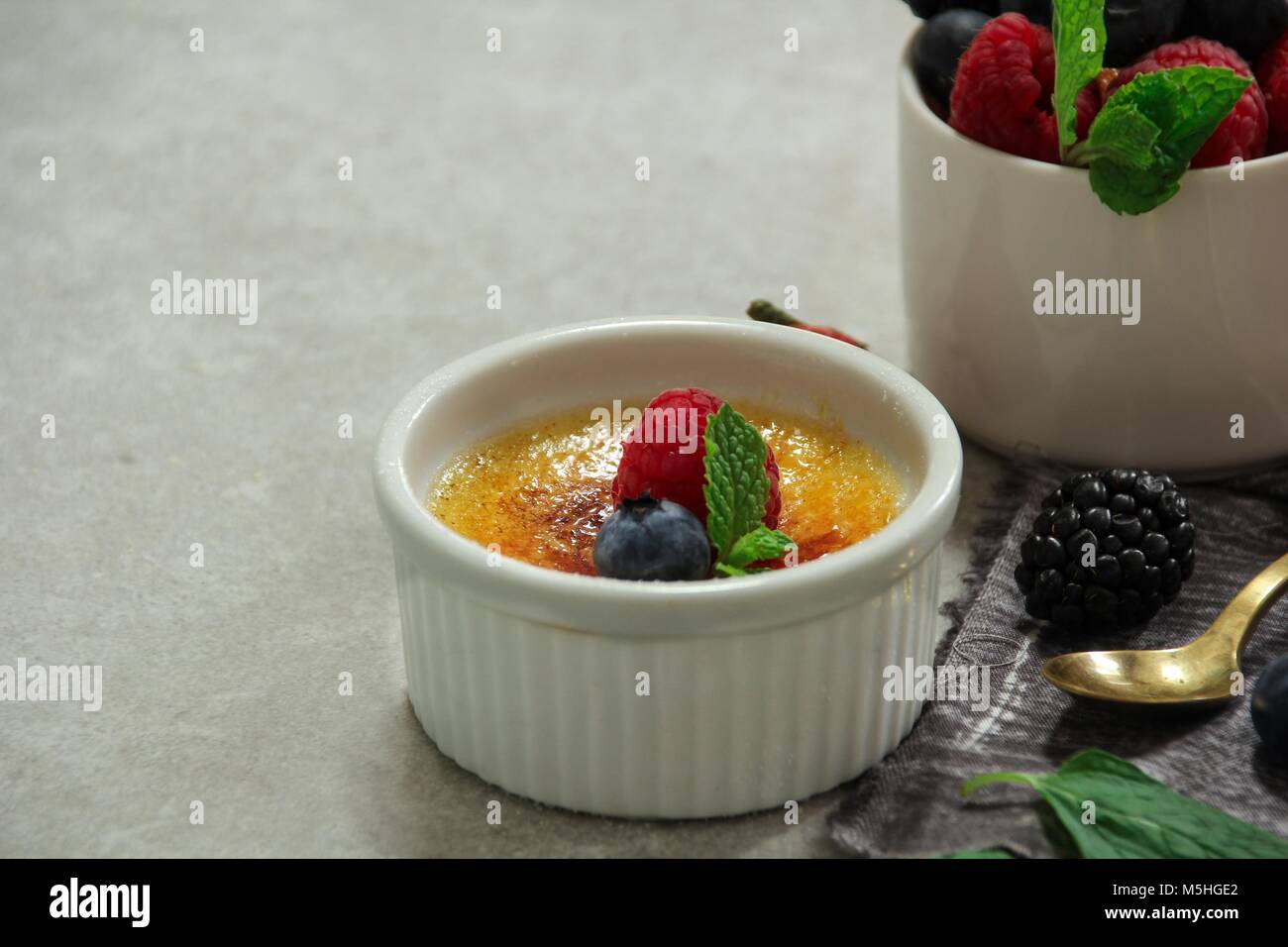 In casa Classic Creme brulee con zucchero bruciato berry topping, il fuoco selettivo Foto Stock