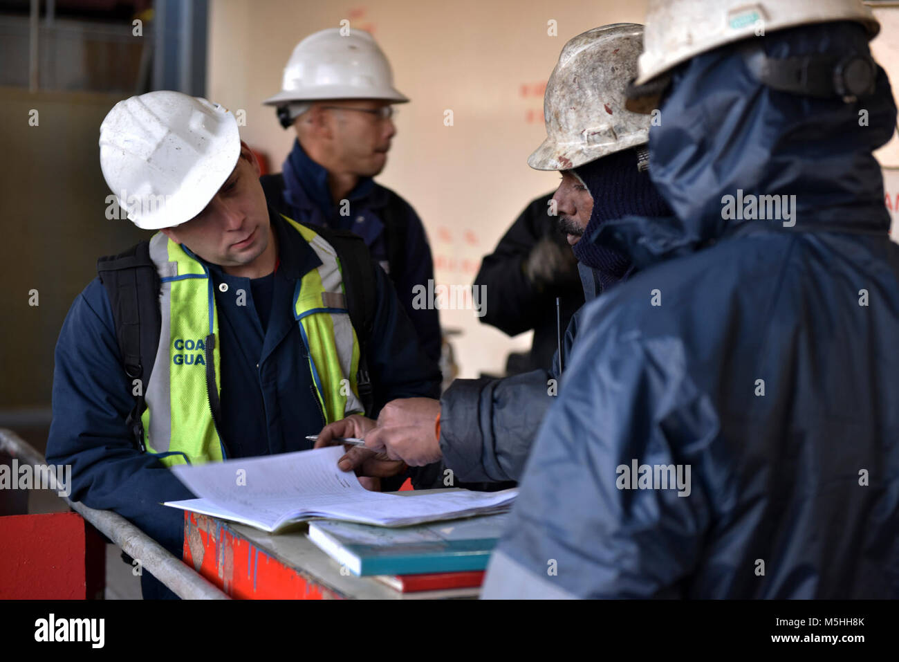 Coast Guard Settore Puget Sound investigatori marine accedi con un membro dell'equipaggio a bordo della 876 piedi di portacontainer MOL PRESTIGE, 12 febbraio 2018, presso il Molo 18 nel porto di Seattle per iniziare le indagini preliminari sulle cause della sala motori Fire come ha iniziato il suo viaggio a Tokyo in Giappone, il 1 febbraio. La guardia costiera conduce una media di più di 70.000 recipiente interno ispezioni e 10.000 del controllo dello Stato di approdo esami di navi straniere conformemente alle normative federali. Stati Uniti Coast Guard Foto Stock