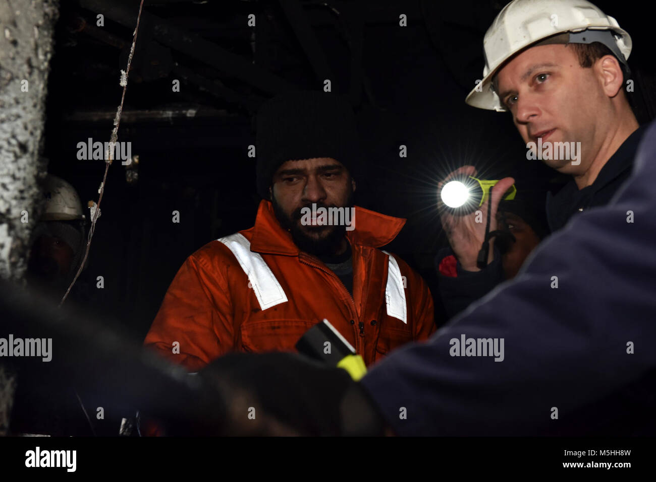 Una guardia costiera settore Puget Sound investigatore marino parla con un membro dell'equipaggio a bordo della 876 piedi di portacontainer MOL PRESTIGE il 12 febbraio 2018, presso il Molo 18 nel porto di Seattle, mentre inizia le indagini preliminari sulle cause della sala motori Fire come ha iniziato il suo viaggio a Tokyo in Giappone, il 1 febbraio. La guardia costiera conduce una media di più di 70.000 recipiente interno ispezioni e 10.000 del controllo dello Stato di approdo esami di navi straniere conformemente alle normative federali. Stati Uniti Coast Guard Foto Stock