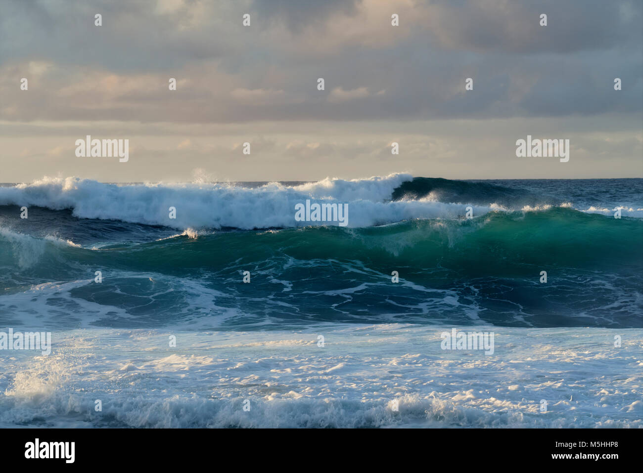 Luce della Sera come grandi onde costruire lungo la North Shore a ke'e sulla spiaggia di Hawaii dell Isola di Kauai. Foto Stock