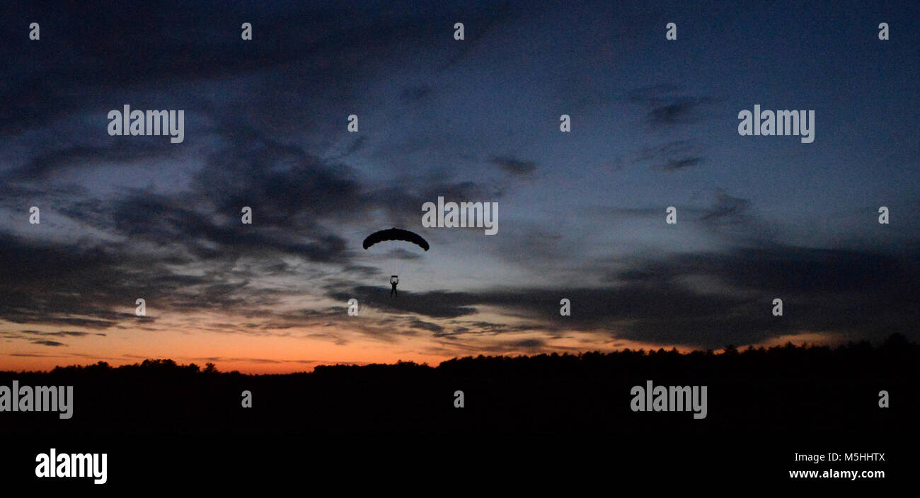 Un pararescueman del New York Air National Guard 106ª Ala di salvataggio scende dopo il salto di un HC-130P/N re aerei sopra Francesco S. Gabreski Air National Guard Base, N.Y., Dic 19, 2017. Durante la tettoia volo un pararescueman sarà pilota il paracadute per un atterraggio di precisione. (U.S. Air National Guard Foto Stock