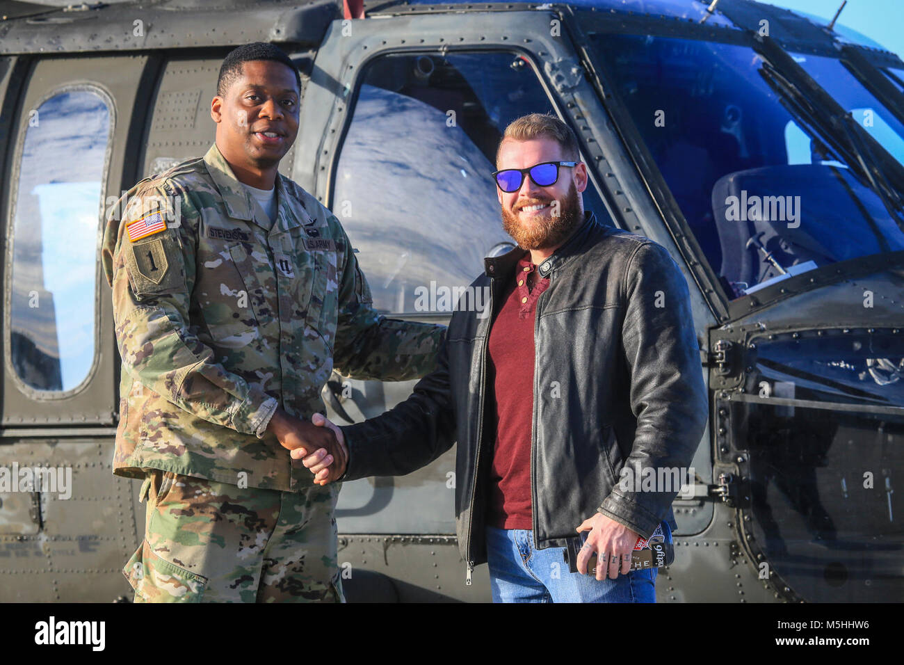 Stati Uniti Esercito Capt. Andre Stevenson, a sinistra, si erge con la CPL. Rory Hamill, un combattimento-feriti Marine, di fronte a New Jersey Guardia Nazionale UH-60L Black Hawk elicottero sulla base comuneGuire-Dix Mc-Lakehurst, N.J., 21 dicembre 2017. (U.S. Air National Guard Foto Stock