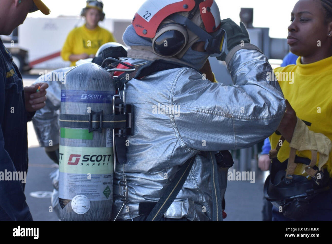 Stati Uniti 5TH FLOTTA AREA DI OPERAZIONI (feb. 10, 2018) Aviation Boatswain compagno del gestore di seconda classe Chernika Sanders (destra) assiste un marinaio con ingranaggio regolazioni prima di un ponte di volo trapano di estinzione mentre in corso a bordo della USS Lewis B. estrattore (ESB 3). La expeditionary base mobile supporta la piattaforma navale Forza anfibia, Task Force 51/5th Marine Expeditionary Brigade diverse missioni che includono la risposta alle crisi, airborne miniera contromisure contro la pirateria operazioni, le operazioni di sicurezza marittima e di aiuti umanitari/Disaster Relief missioni pur consentendo TF 51/5 per estendere la sua expeditiona Foto Stock