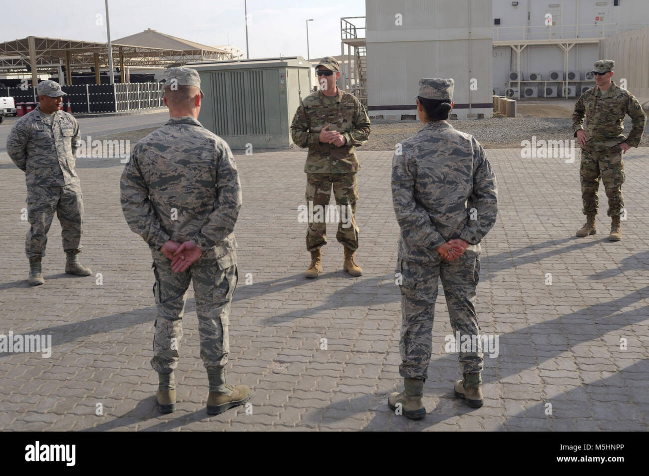 Stati Uniti Air Force Col. Eric Rivera, U.S. Forze Aeree del comando centrale riserva aria componente advisor, monete due avieri al di fuori dell'aria 380 Ala Expeditionary headquarters building Al Dhafra Air Base, Emirati Arabi Uniti, febbraio 7, 2018. L'origine di coniatura di aviatori risale alla prima guerra mondiale, tuttavia oggi essi sono utilizzati come cimeli di riconoscere le prestazioni eccezionali e il duro lavoro dei membri del servizio. (U.S. Air Force Foto Stock