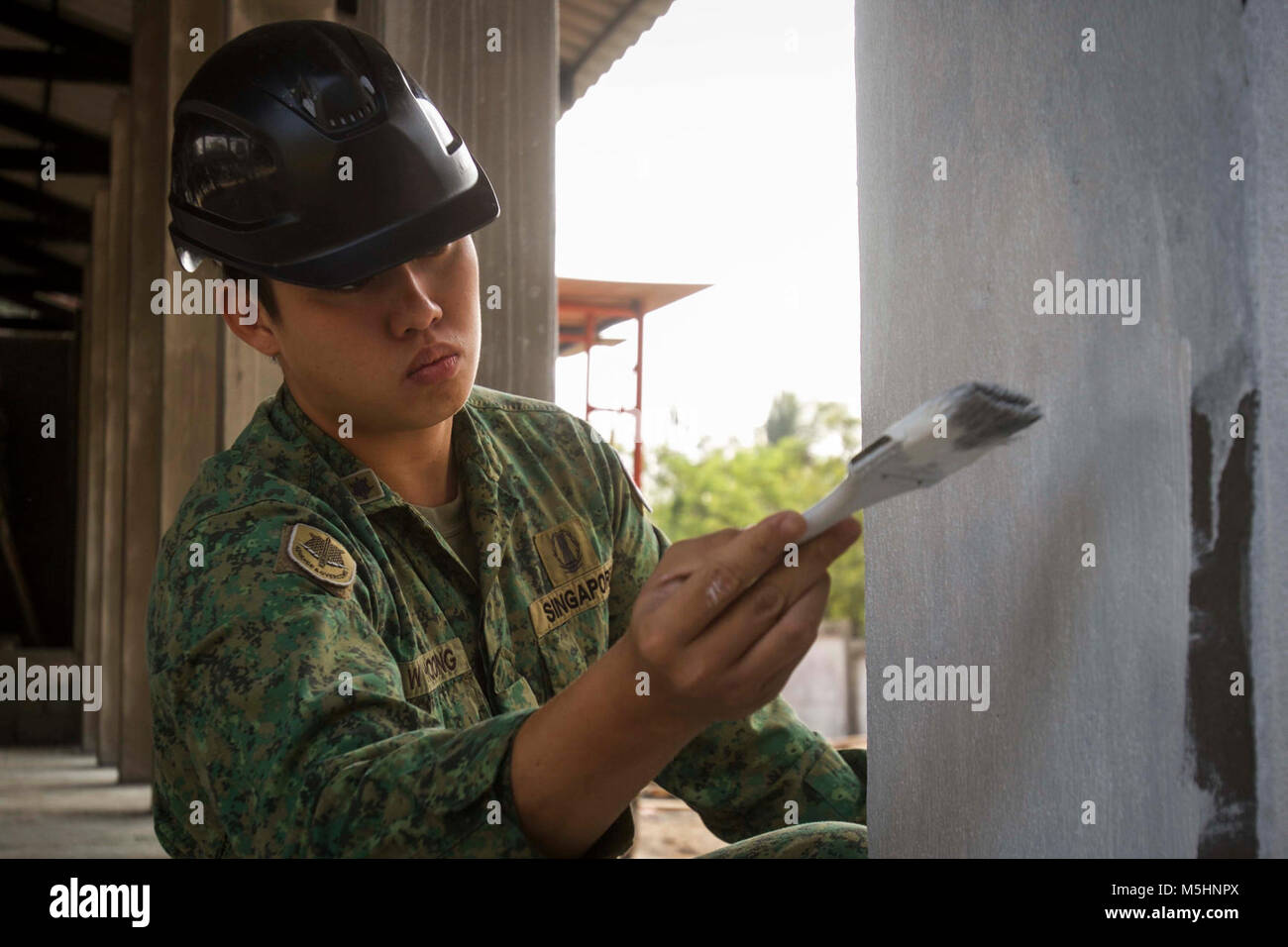 Soldato di Singapore LTA Hoong Shi Wei, un esercizio di comandante di plotone con la sede Army Combat Engineer Gruppo, dipinge un pilastro per un progetto di costruzione a scuola Somboonnaram a sostegno del Cobra Gold 2018 nella provincia di Rayong, Regno di Thailandia, Febbraio 8, 2018. Il Thai Royal Navy, U.S. Marina e l esercito di Singapore a lavorare insieme per costruire un nuovo edificio polifunzionale per la scuola. Cobra Gold 18 è un esercizio annuale condotta nel Regno di Thailandia e corre da Feb. 13-23 con sette nazioni partecipanti. (U.S. Marine Corps Foto Stock