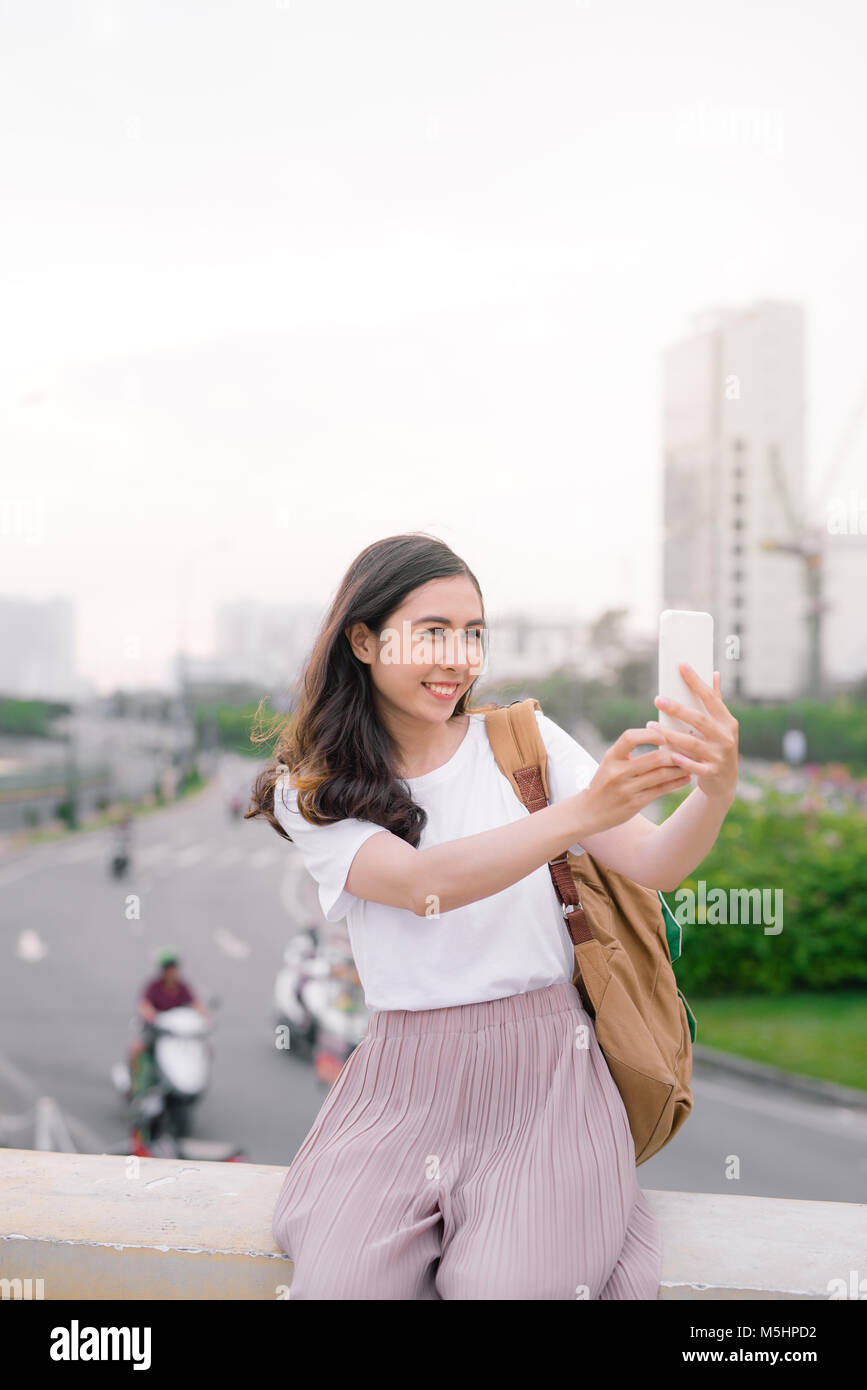 Giovane bella con lunghi capelli donna prendendo selfie all'aperto. Foto Stock