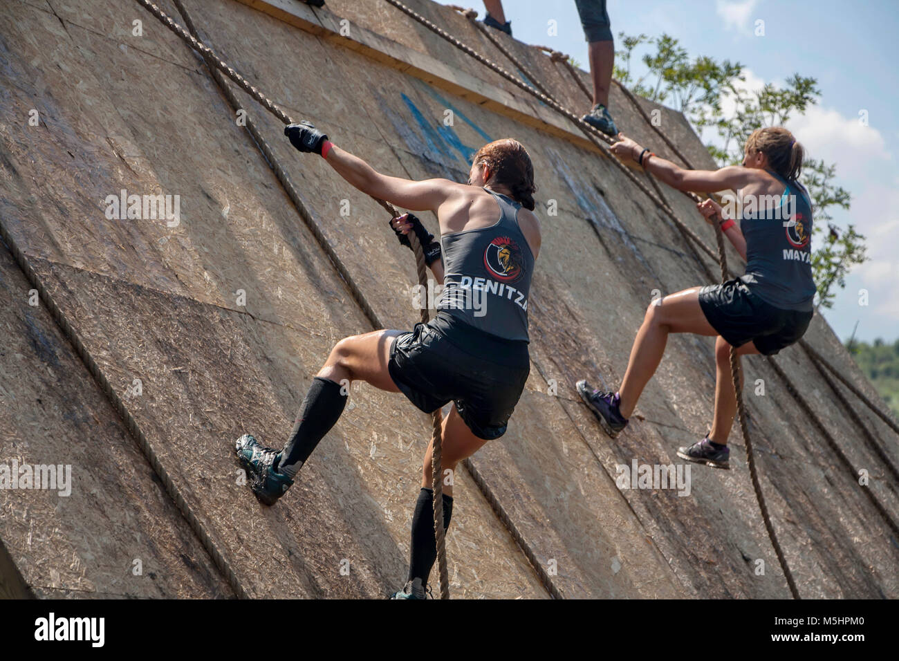 Due donne arrampicata con corde in quasi la parete verticale in corrispondenza della corsa di resistenza Legion eseguire svoltasi a Sofia, in Bulgaria il 26 Luglio 2014 Foto Stock