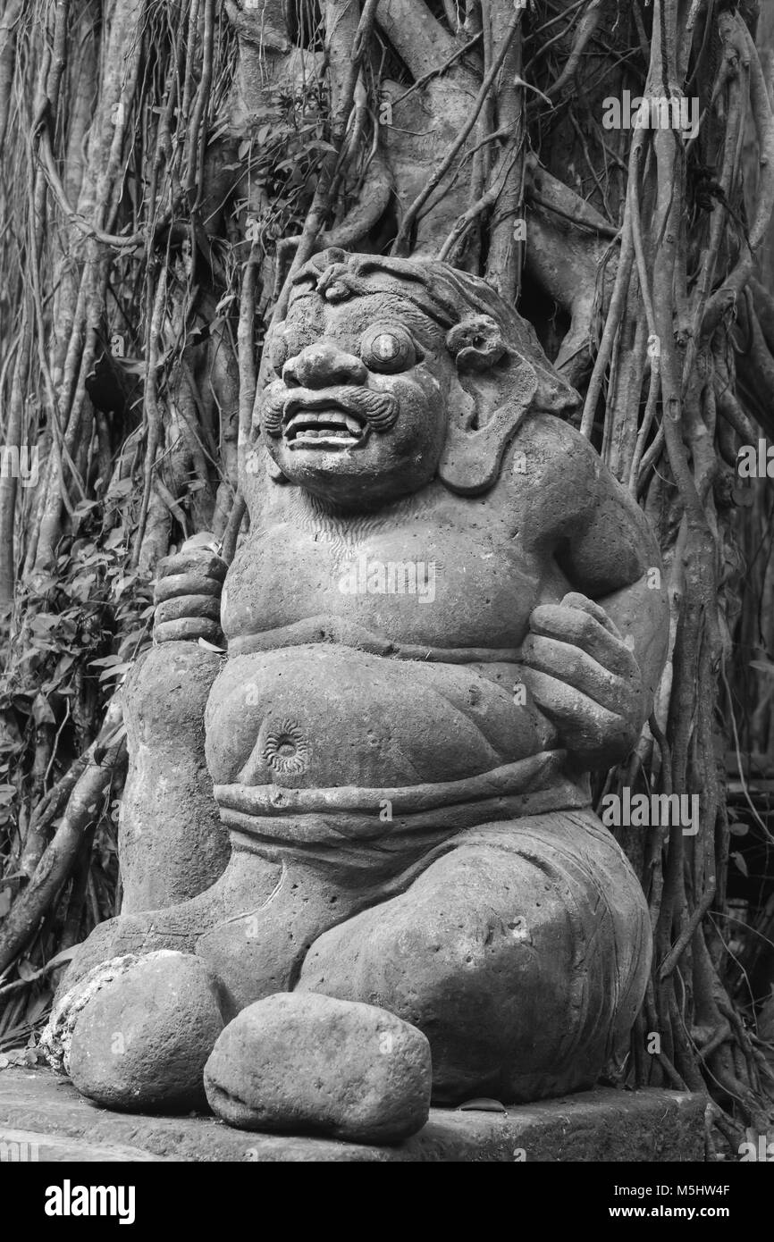 Orco statua con fig radici, sacro Santuario della Foresta delle Scimmie, Ubud, Bali Foto Stock