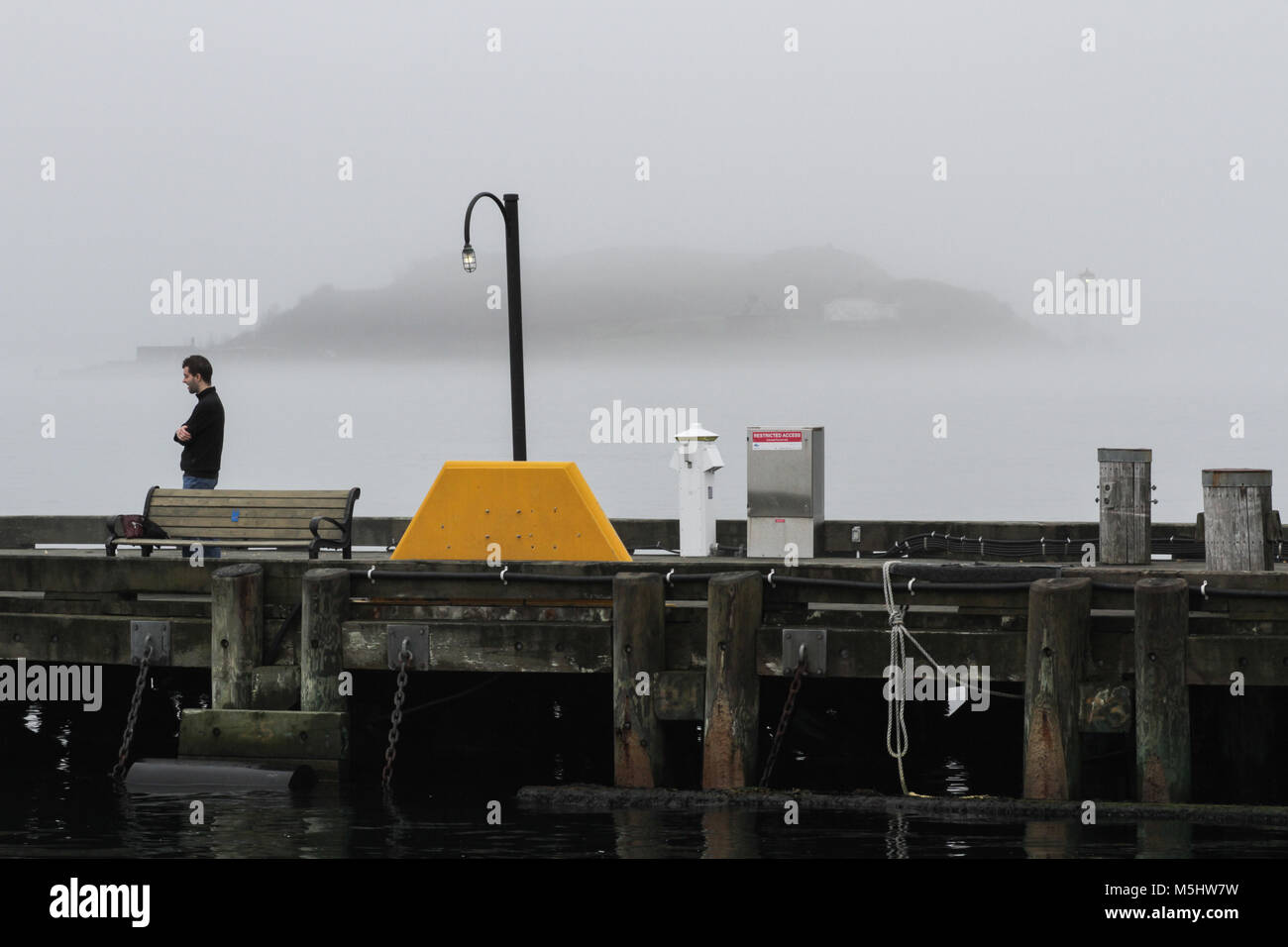 Una persona che cammina sul lungomare di Halifax, ad Halifax, Nova Scotia Foto Stock