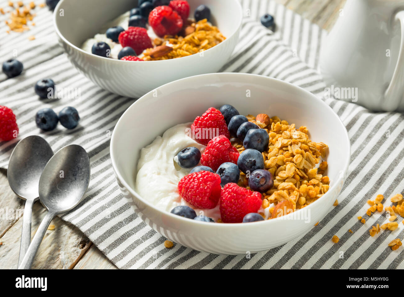 Organico sano lo yogurt greco con cereali e frutti di bosco in una ciotola Foto Stock