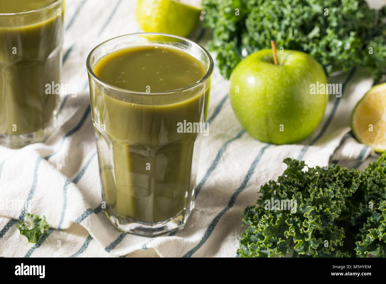 Un sano verde biologico frullato di succo in un bicchiere Foto Stock