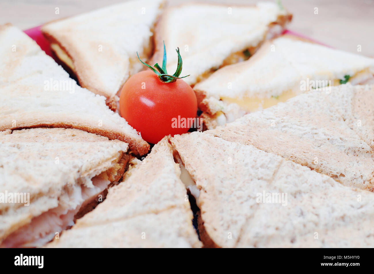 Colazione: panini con formaggio e prosciutto, decorate con i pomodori ciliegia Foto Stock