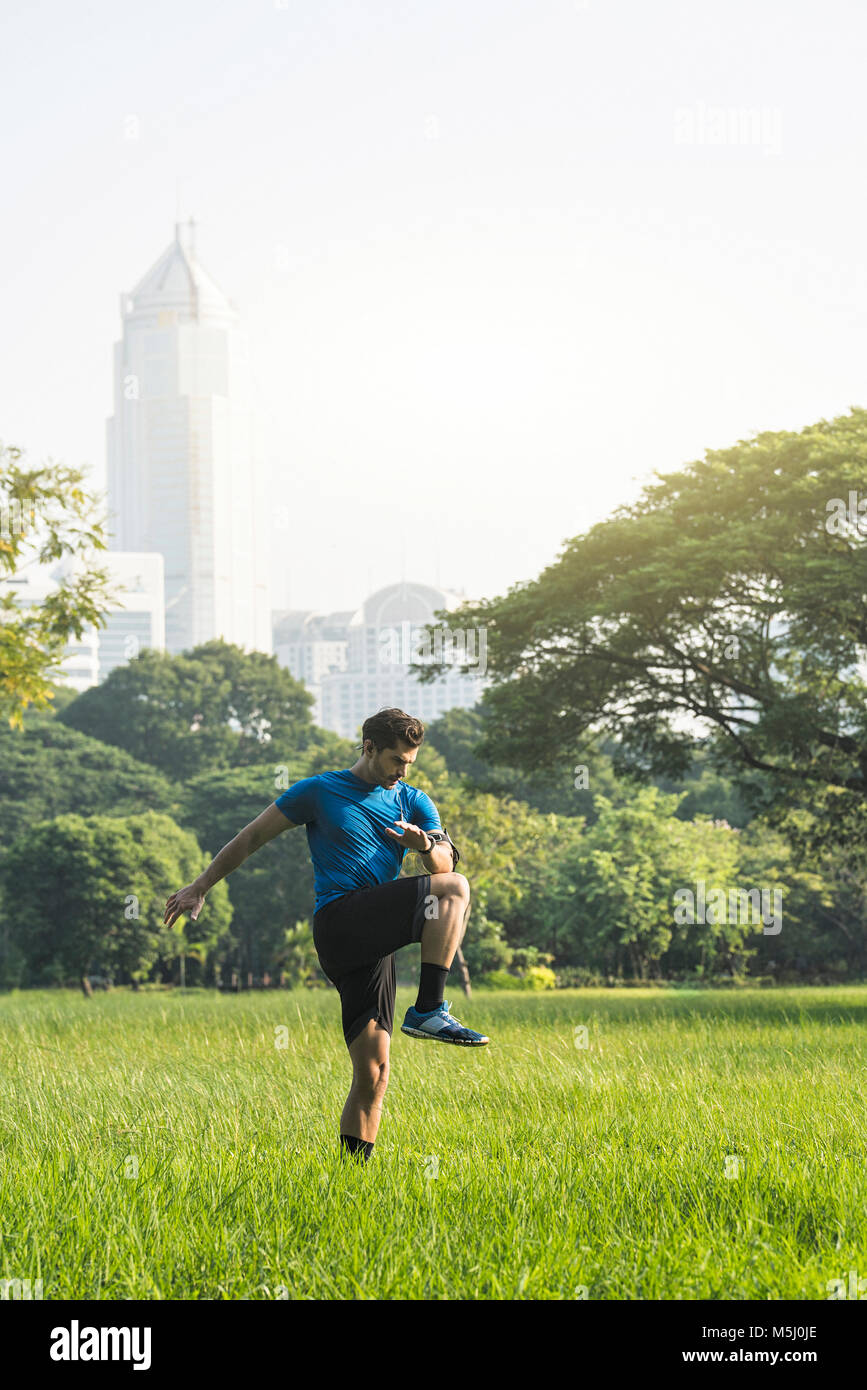 Runner in fase di riscaldamento nel parco urbano Foto Stock