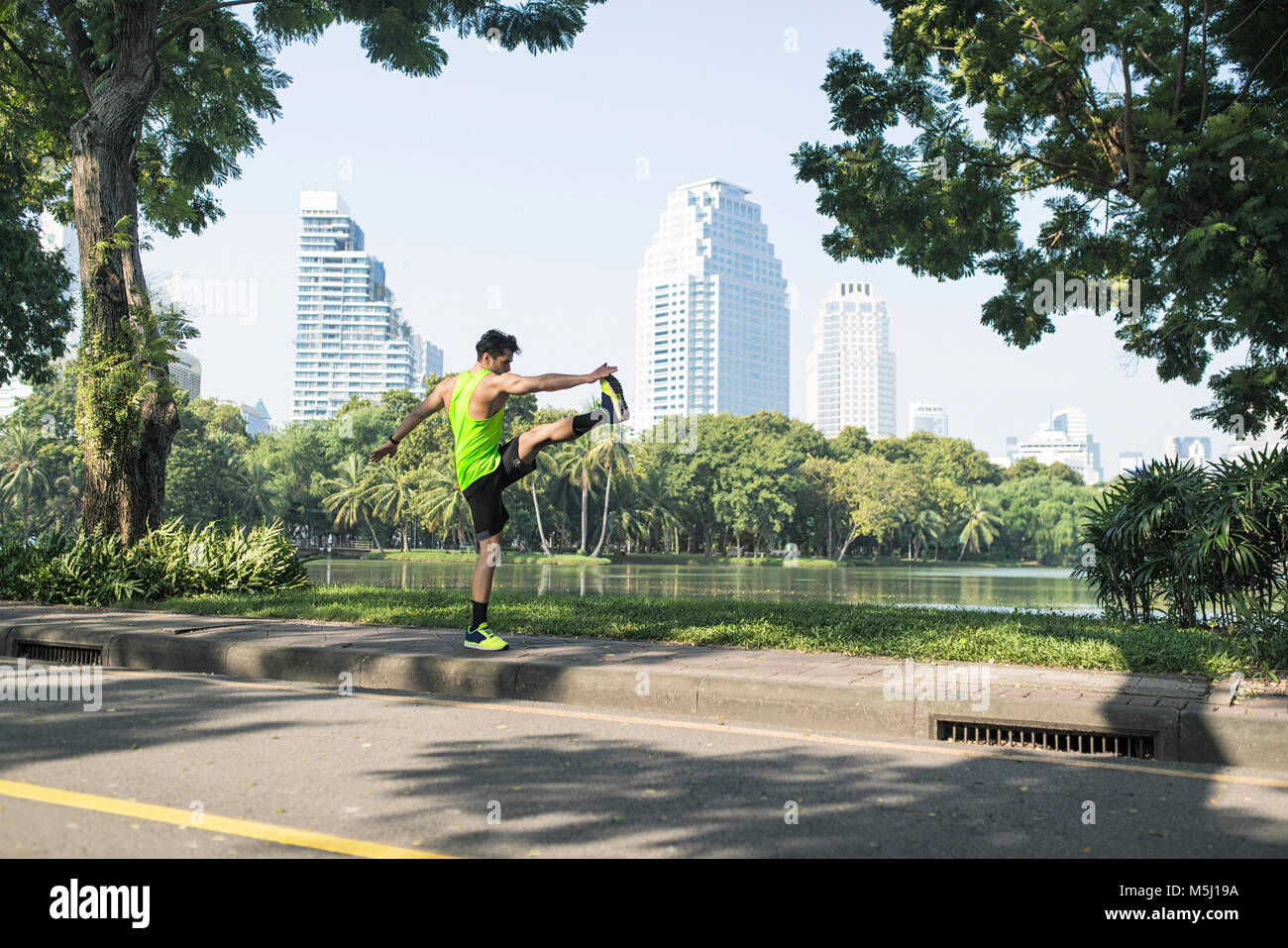 Runner in fase di riscaldamento nel parco urbano Foto Stock