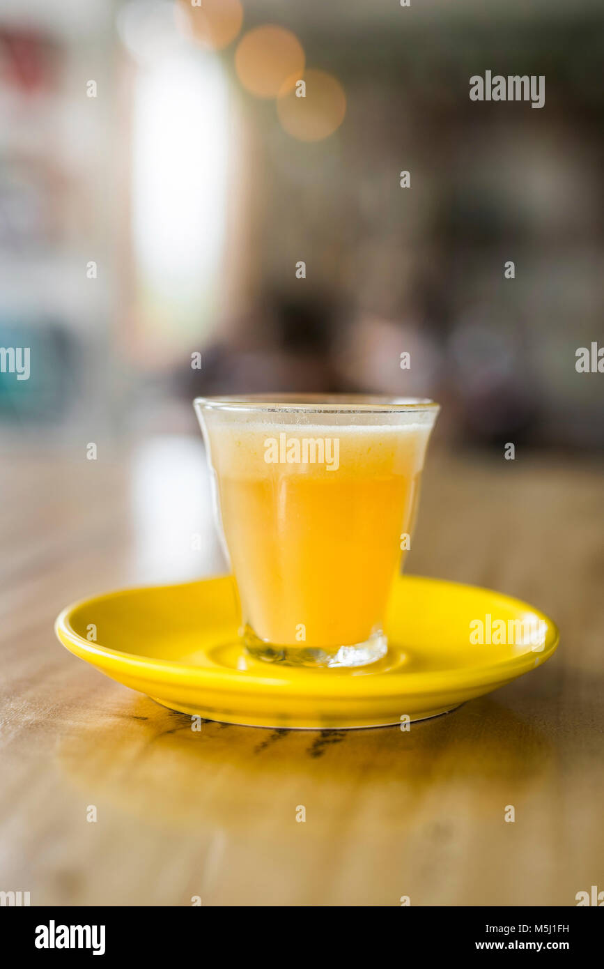 Bevanda arancione in vetro sul racconto di legno Foto Stock