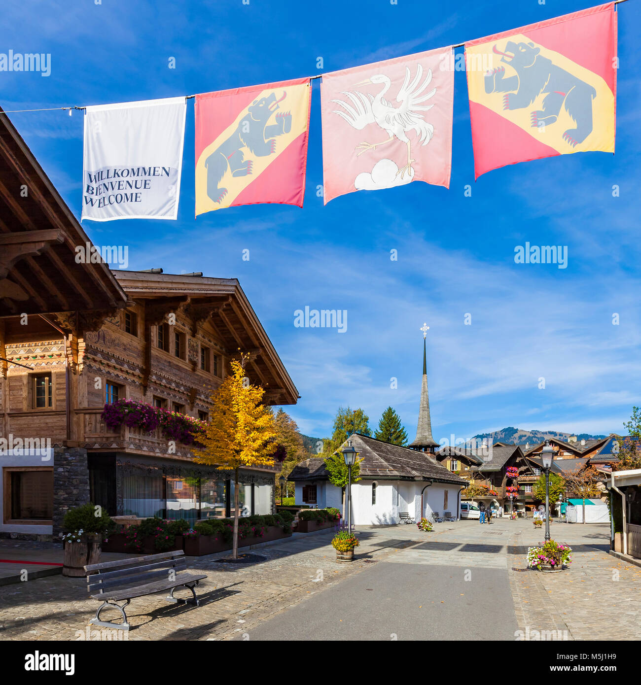 Schweiz, Kanton Bern, Berner Oberland, Saanenland, Gstaad, Nobelferienort, Fußgängerzone, chalet, San Niklaus-Kapelle, Flagge Kanton Bern Foto Stock