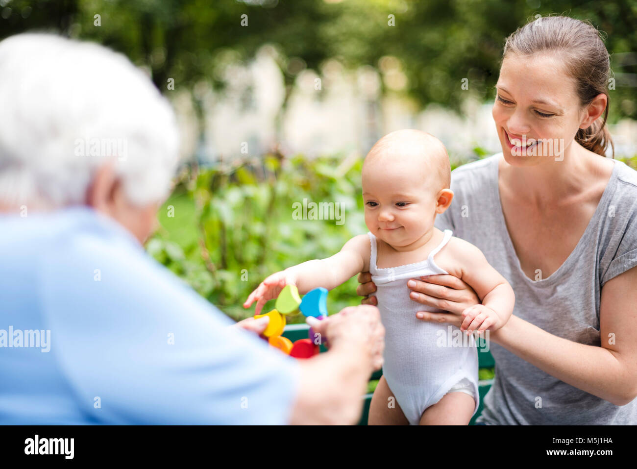 Ritratto di sorridente bambina con la nonna e la madre in un parco Foto Stock
