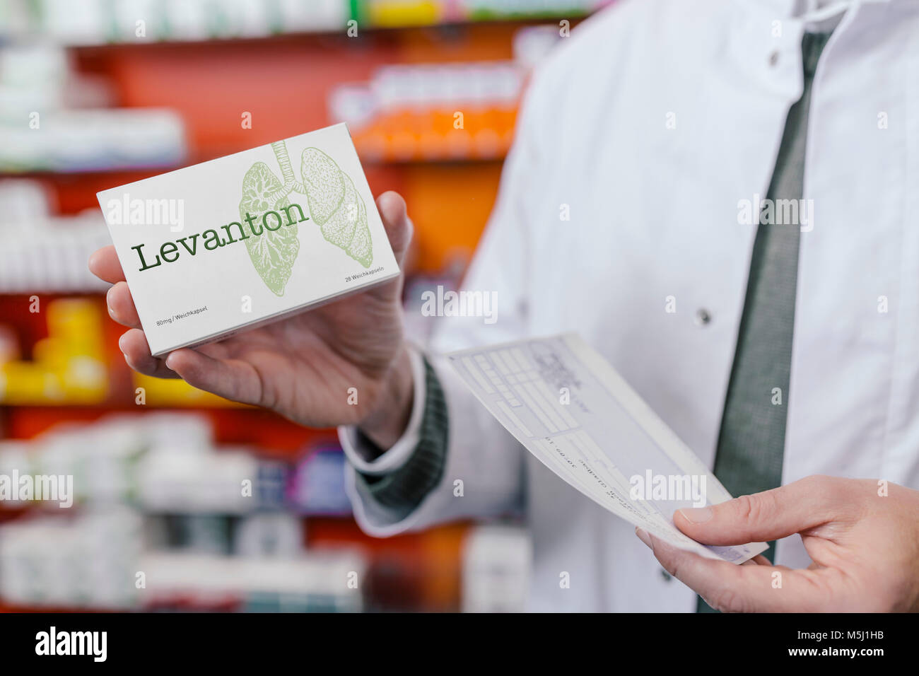 Il farmacista azienda pacchetto compressa e la prescrizione in farmacia Foto Stock
