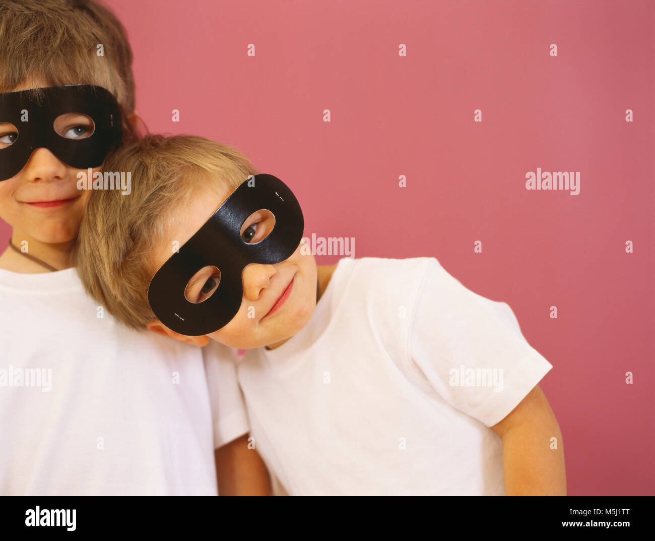 Ritratto di due sorridenti ragazzi piccoli vestita di nero maschere per occhi Foto Stock