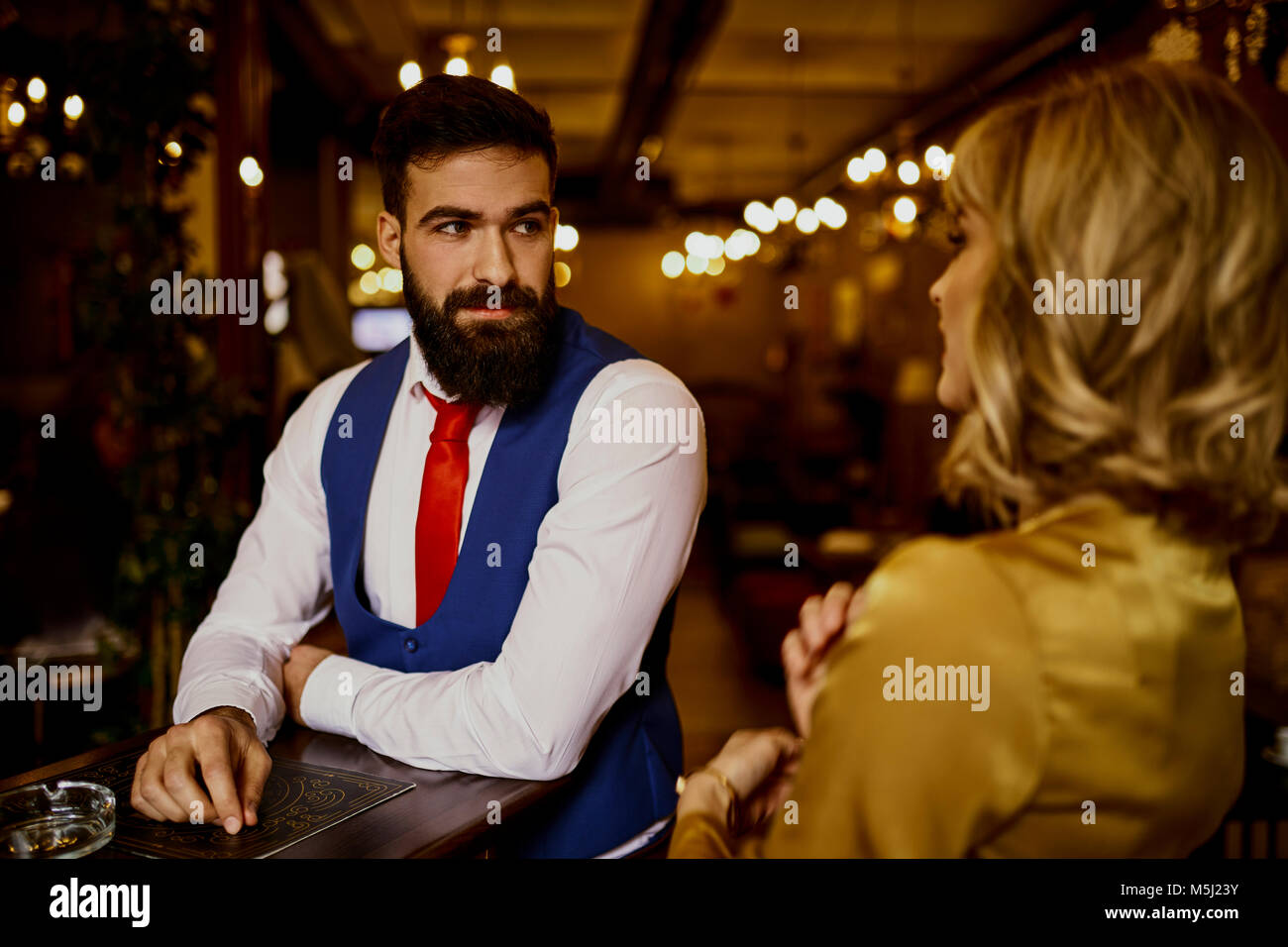 Moda giovane uomo che guarda la donna in un bar Foto Stock