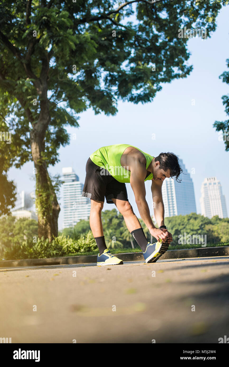 Runner in fase di riscaldamento nel parco urbano Foto Stock