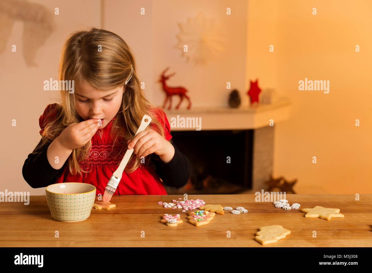 Bambina la farcitura di biscotti di Natale con centinaia e migliaia Foto Stock