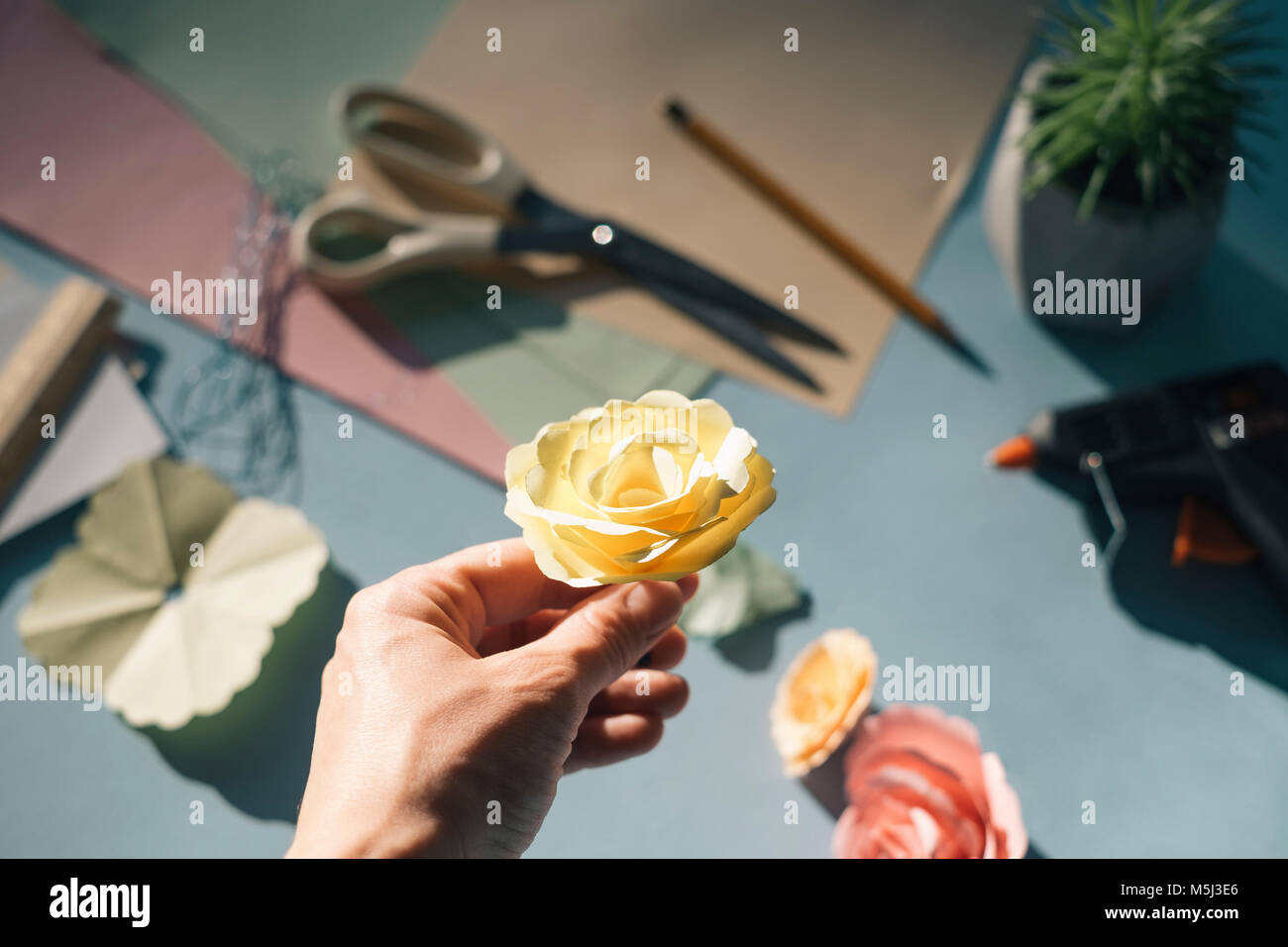 Femmina di mano che tiene una rosa di carta Foto Stock