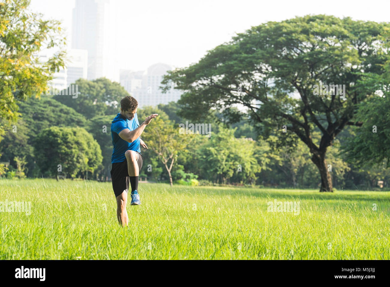 Runner in fase di riscaldamento nel parco urbano Foto Stock