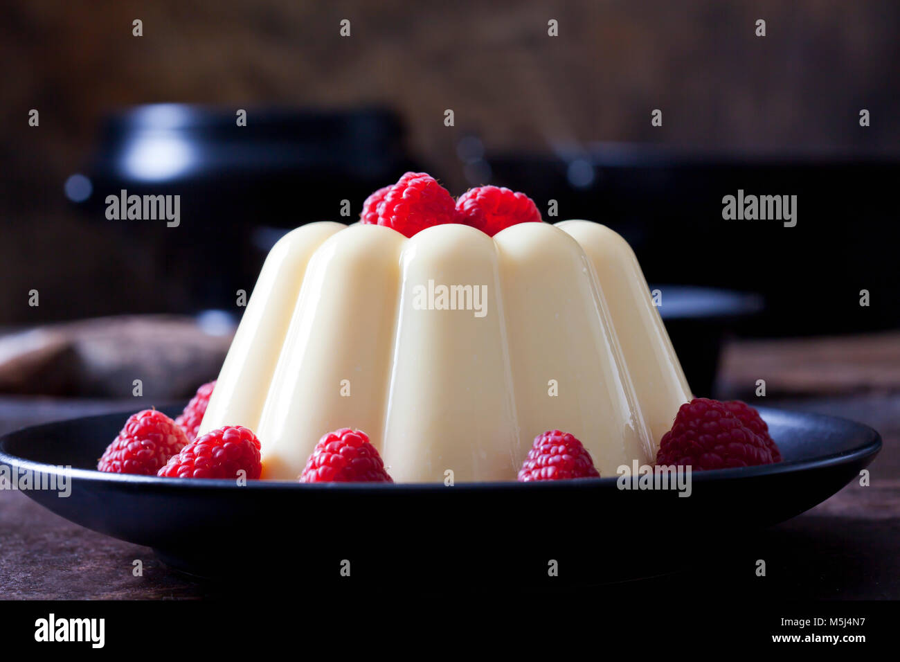 Crema pasticcera con lamponi su piastra Foto Stock