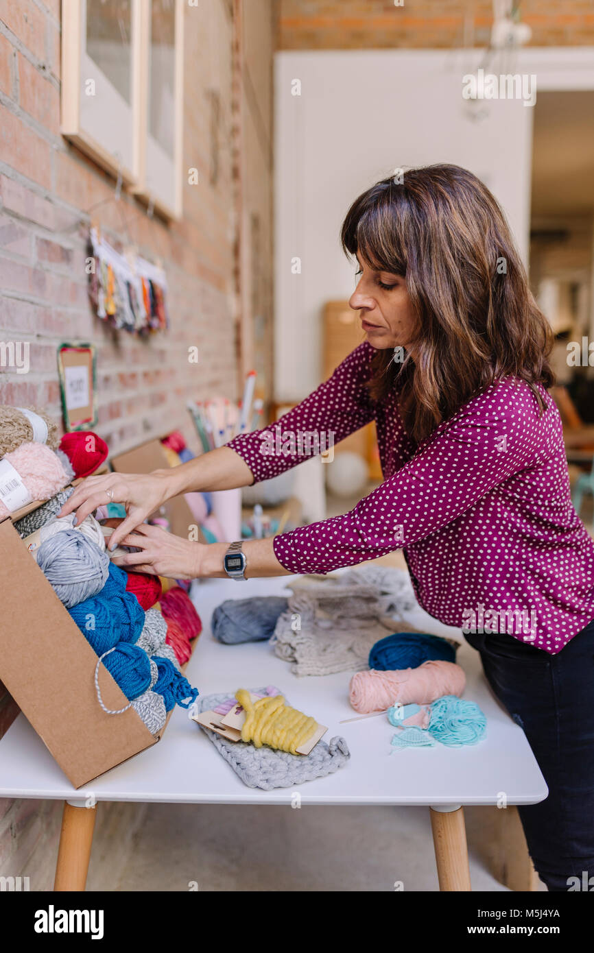 La donna a tavola la scelta di lana per maglieria da assortimento Foto Stock